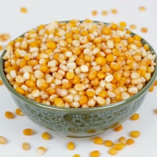 A bowl of mixed yellow and white popcorn kernels.